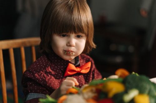 Adorable child enjoying fresh vegetables at the dinner table.
